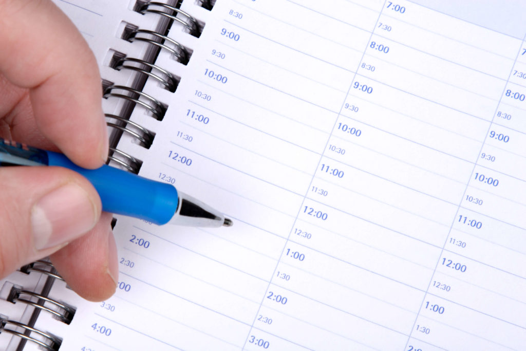 homem anotando na agenda para melhora a produtividade